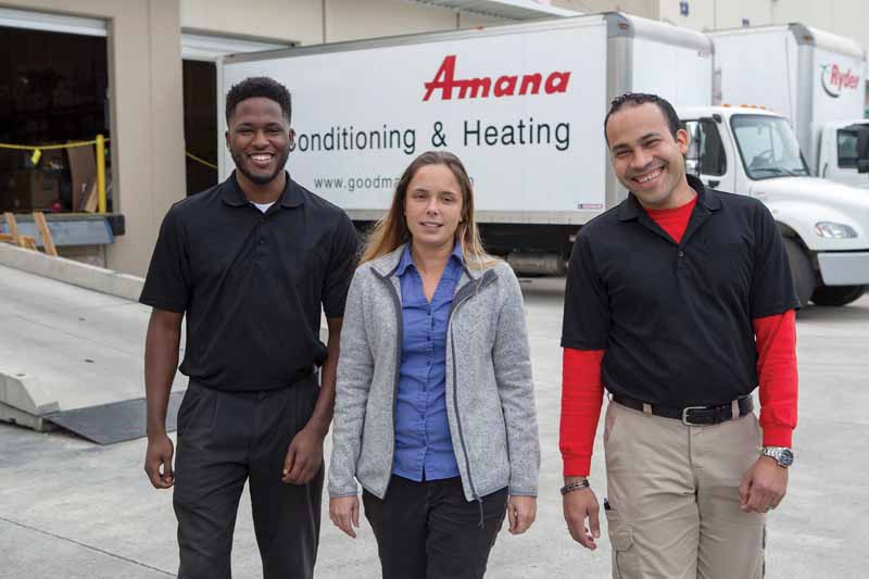 WeaveAire team members standing together in front of an Amana Air Conditioning & Heating delivery truck